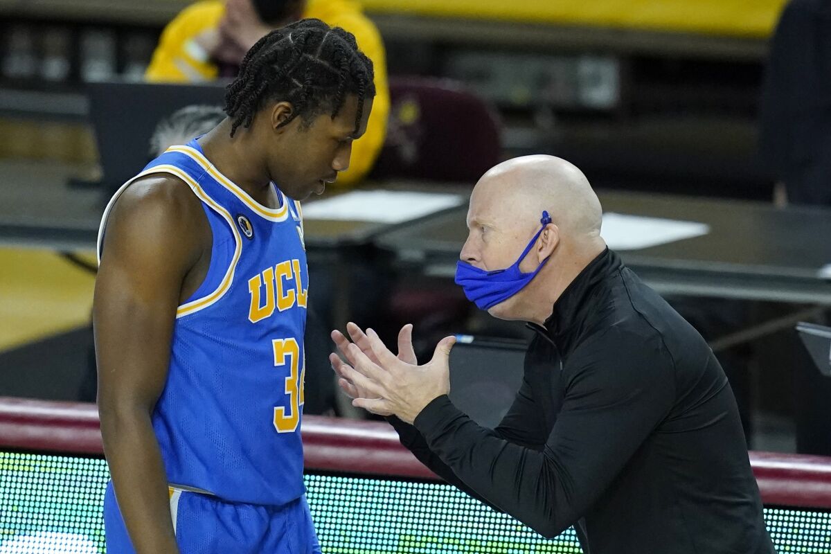 UCLA coach Mick Cronin talks with guard David Singleton.