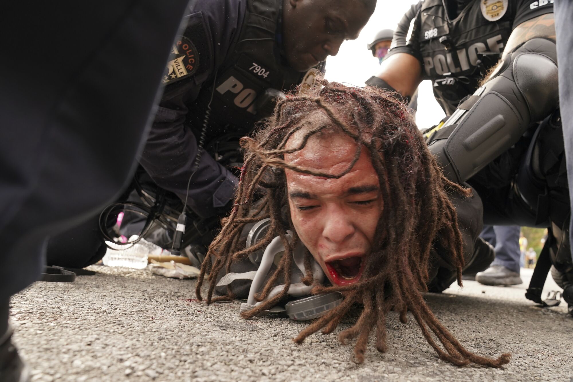 Louisville police detain a man after a group marched in Louisville, Ky.