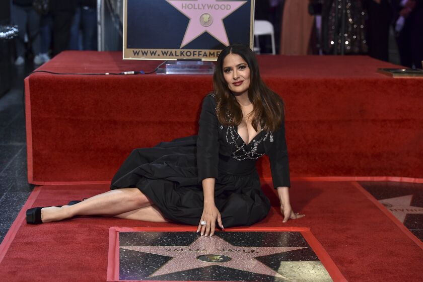Salma Hayek posa junto a su flamante estrella en el Paseo de la Fama de Hollywood el viernes 19 de noviembre de 2021 en Los Ángeles. (Foto por Jordan Strauss/Invision/AP)