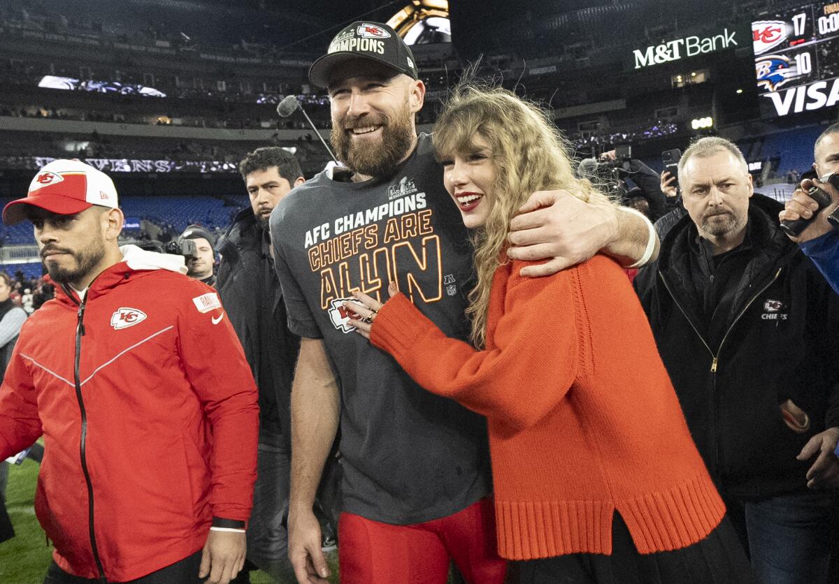 Kansas City Chiefs tight end Travis Kelce and Taylor Swift walk together after an AFC Championship.