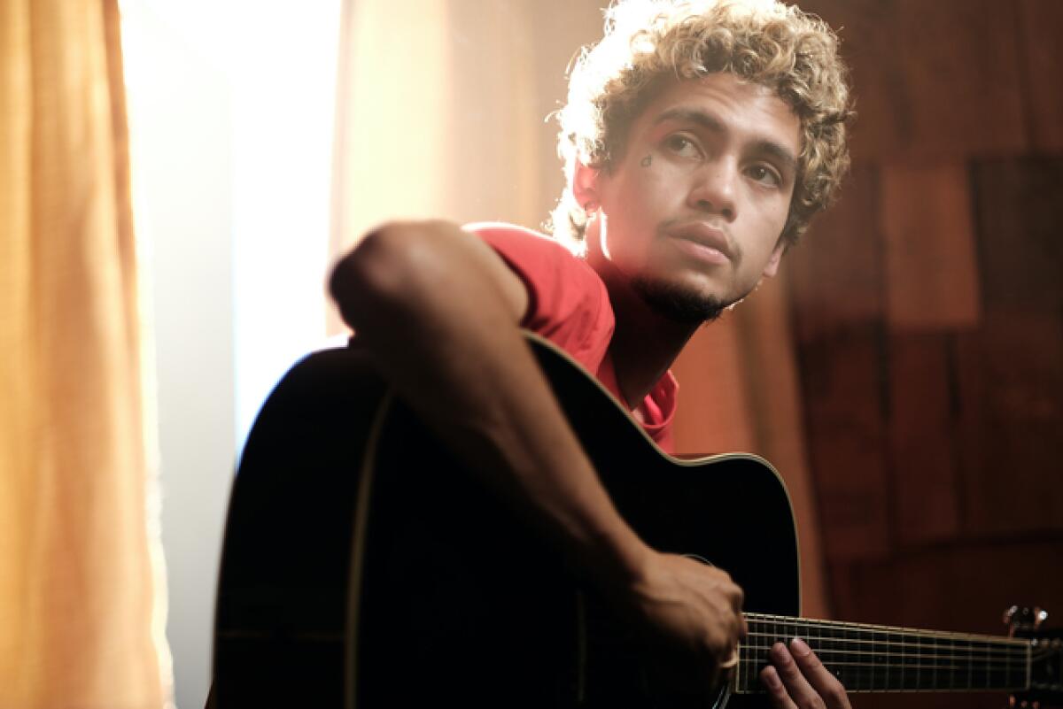 A teenage boy with a guitar