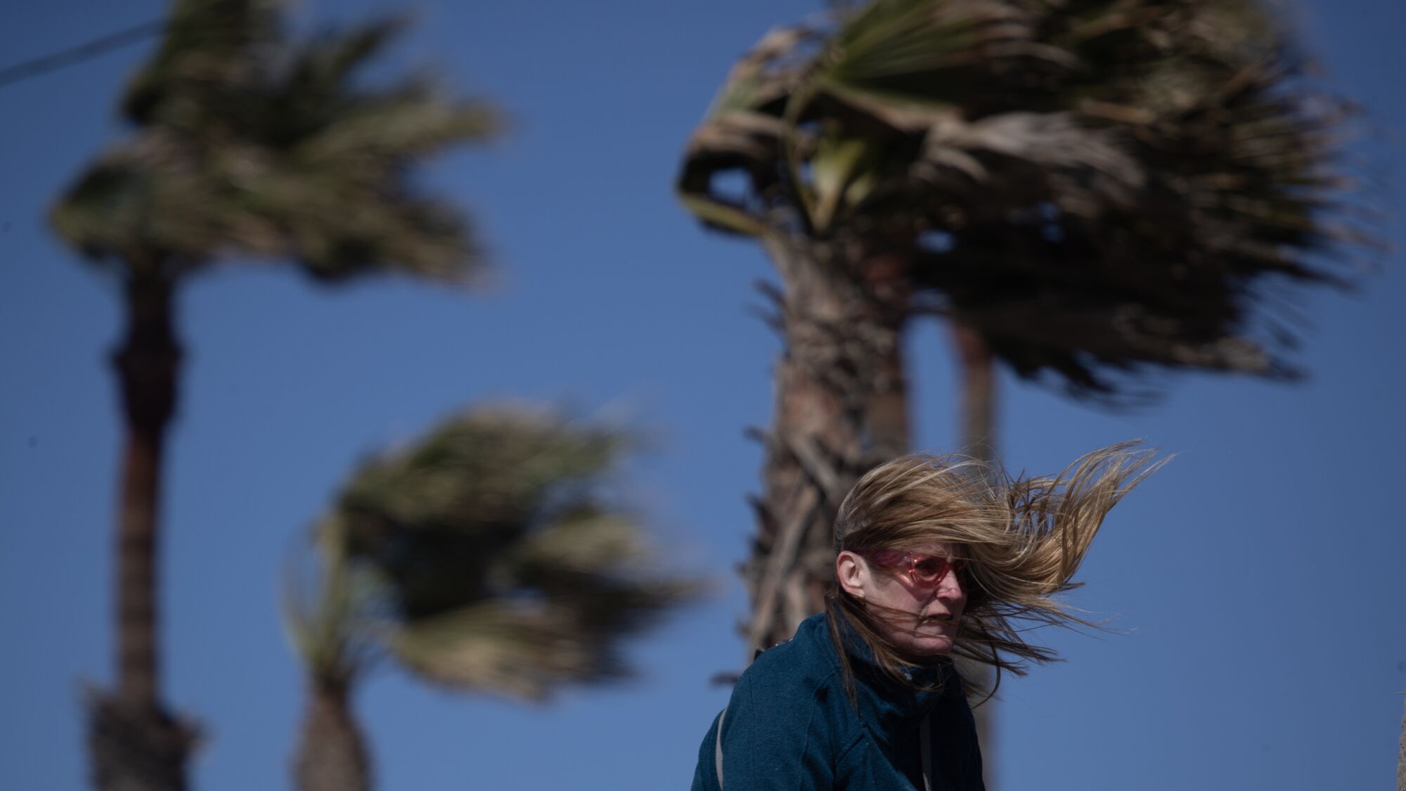 Gusty cold winds blow along the bike path in Huntington Beach Wednesday.