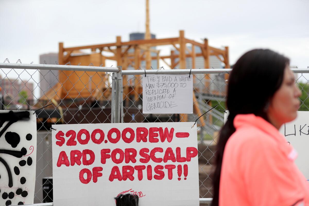 Protest signs outside the Walker Art Center's Minneapolis Sculpture Garden before artist Sam Durant's sculpture "Scaffold" was taken down. (David Joles / Anthony Souffle/ Star Tribune)