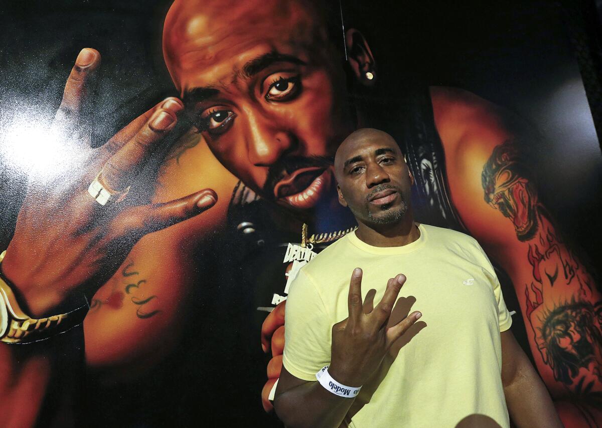 Veteran Jason Pondexter poses in front of a mural of Tupac Shakur in the Art of Music Experience on Thursday.