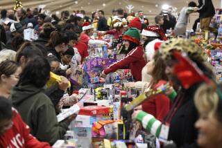 Volunteers, right, hand out toys to families, left, in the Toy Room at the Toys for Joy event held at Abraham Lincoln High School Saturday, Dec. 14, 2019 in San Diego, California. The annual event is put on by the The Rock Church. (Photo by Denis Poroy/Union-Tribune)