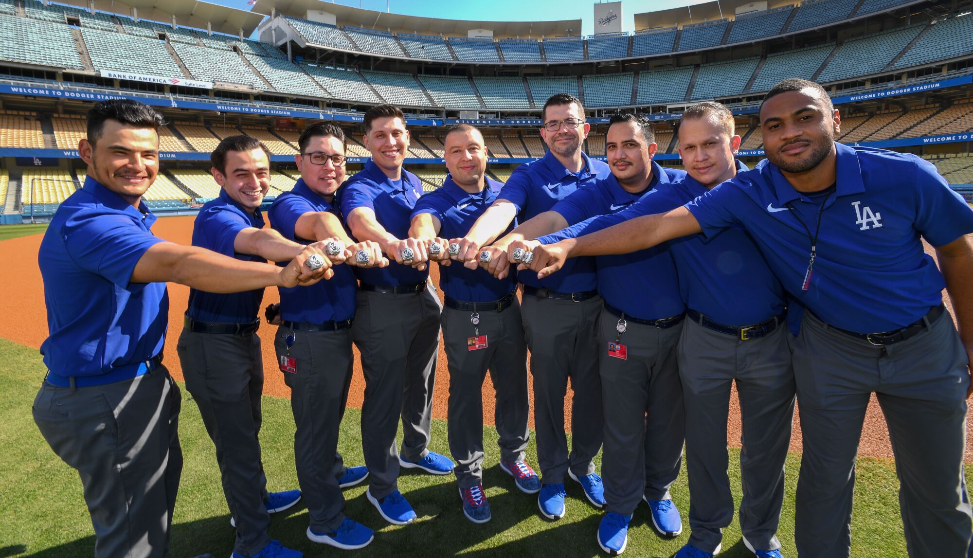 Dodgers clubhouse attendants and bat boys display their 2020 World Series rings.