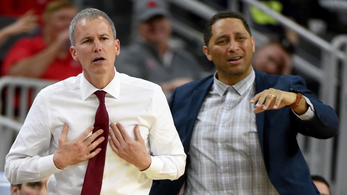 USC coach Andy Enfield, left, and associate head coach Tony Bland react to a play during a Pac-12 tournament game against UCLA on March 9, 2017, in Las Vegas.
