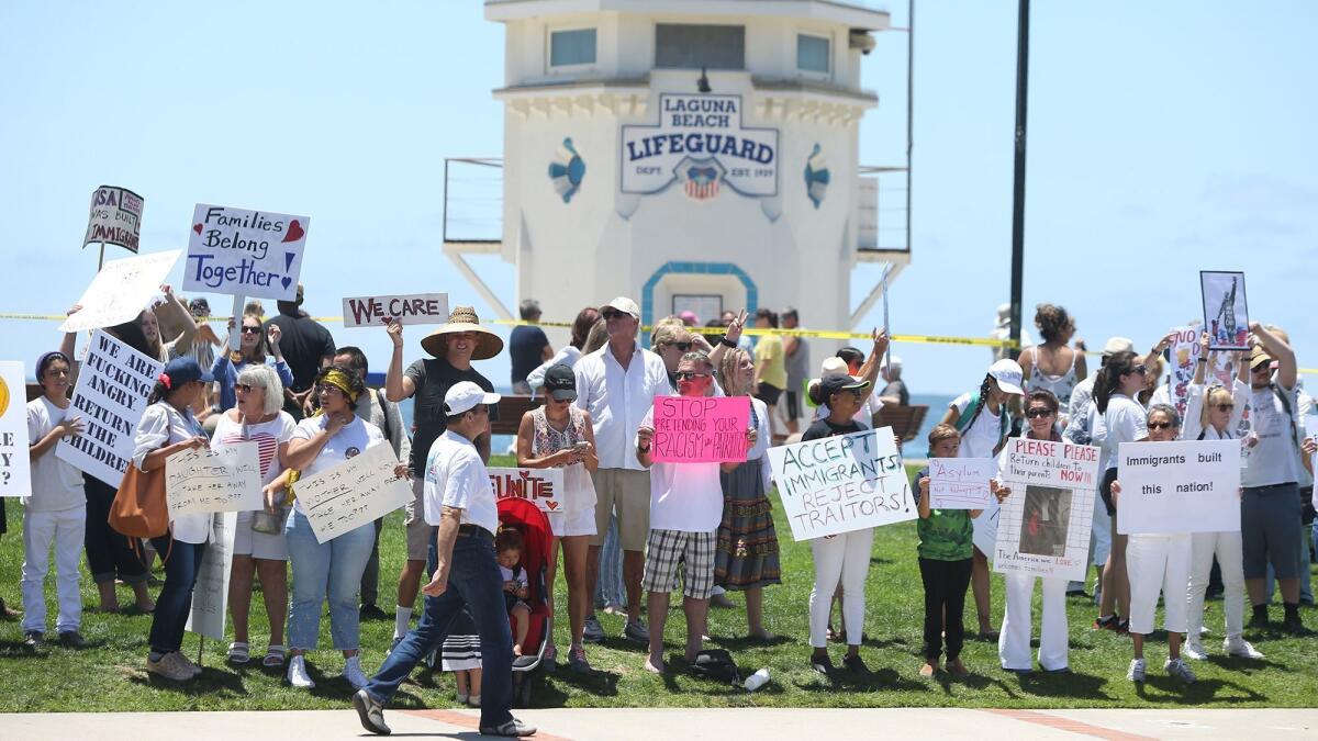 Demonstrators gather to protest the latest Trump administration immigration policies at Main Beach in Laguna Beach on Saturday.