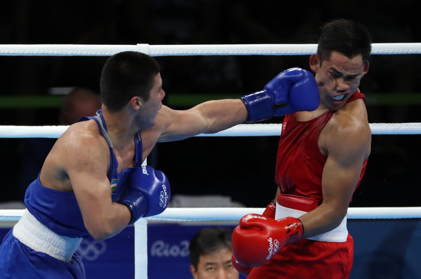 Bektemir Melikuziev de Uzbekistán (i) en acción contra el mexicano Misael Rodríguez (d) durante la semifinal de boxeo de 75 kilogramos de los Juegos Olímpicos Río 2016.
