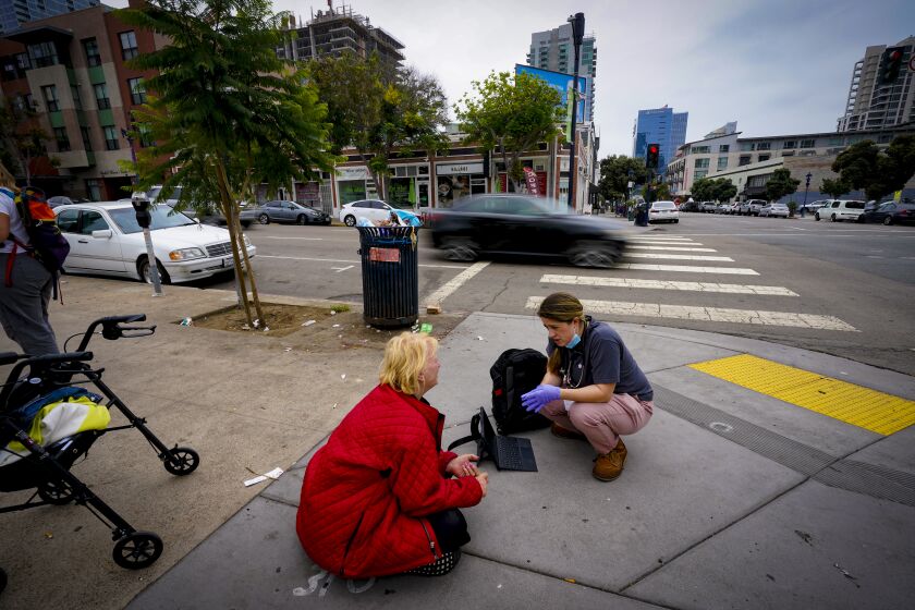 San Diego, CA - September 30: On Friday, Sept. 30, 2022 in downtown San Diego, CA., Teagan Flint (r), physician assistant with Healthcare in Action spoke with Betty McDaniel (l), 59 near a homeless encampment on the corner of F Street. (Nelvin C. Cepeda / The San Diego Union-Tribune)