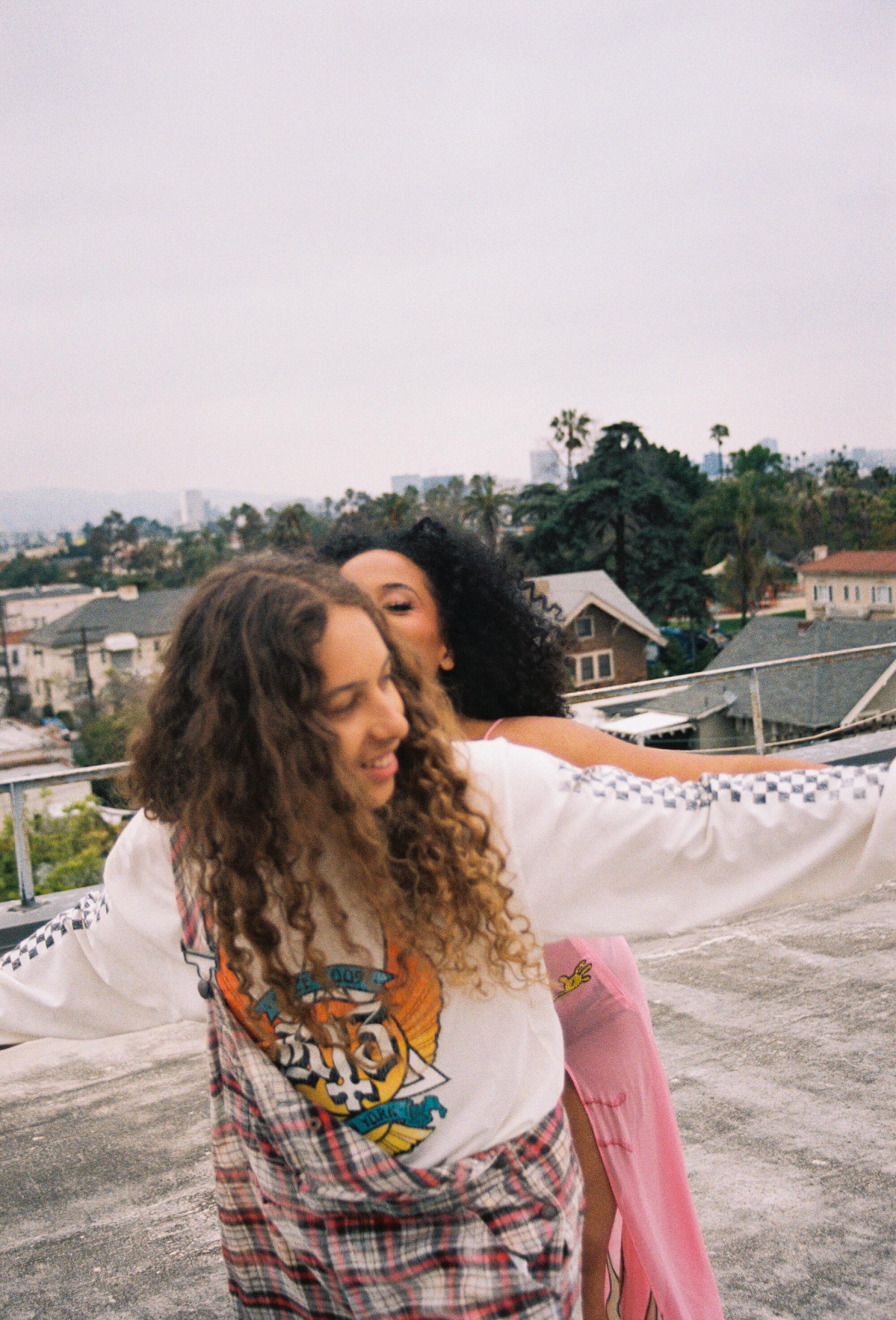 Two people embrace on a rooftop.