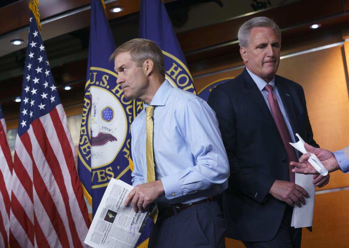 Reps. Jim Jordan and Kevin McCarthy exchange places at the microphones during a news conference.