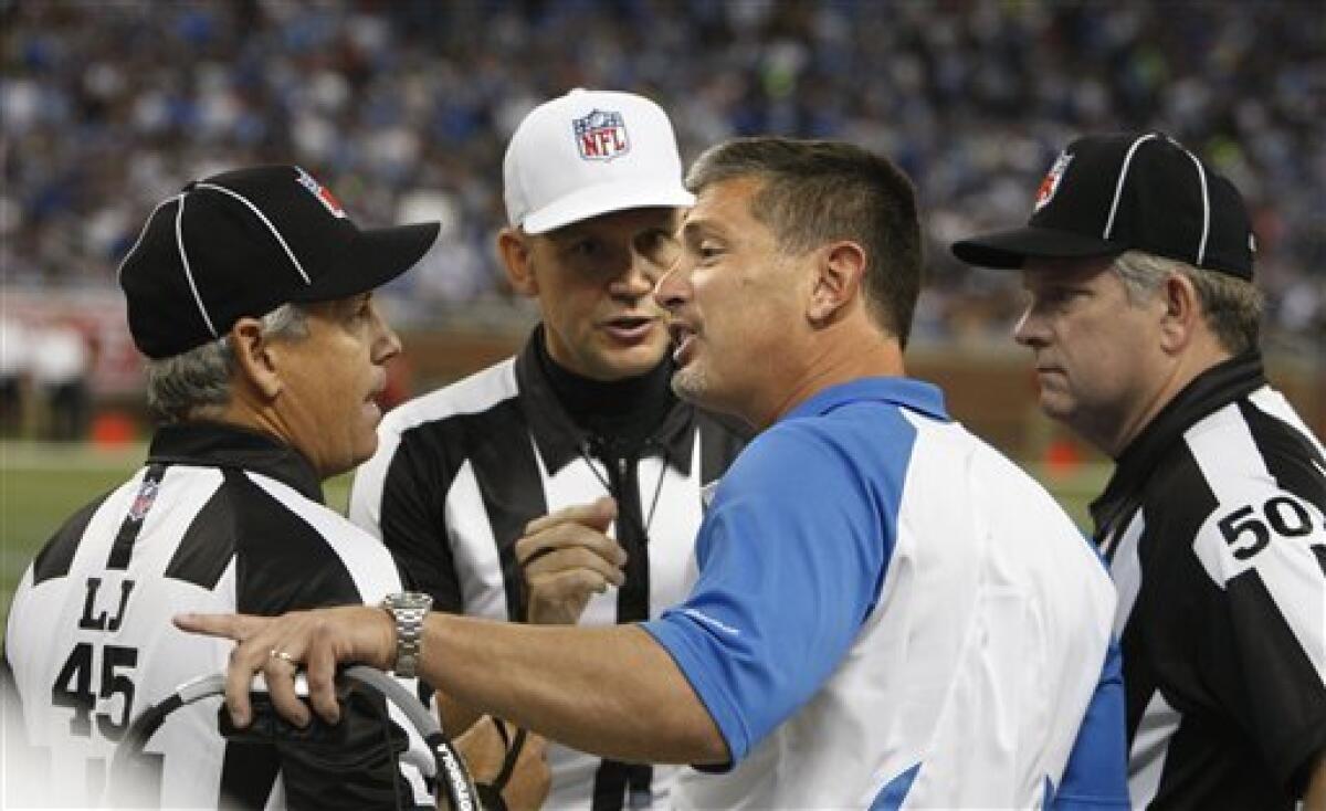 Detroit Lions head coach Jim Schwartz argues a call with line judge Jeff Seeman (45), field judge Mike Weir (50) and referee Clete Blakeman during the first quarter of an NFL football game at Ford Field in Detroit, Sunday, Sept. 19, 2010. (AP Photo/Carlos Osorio)