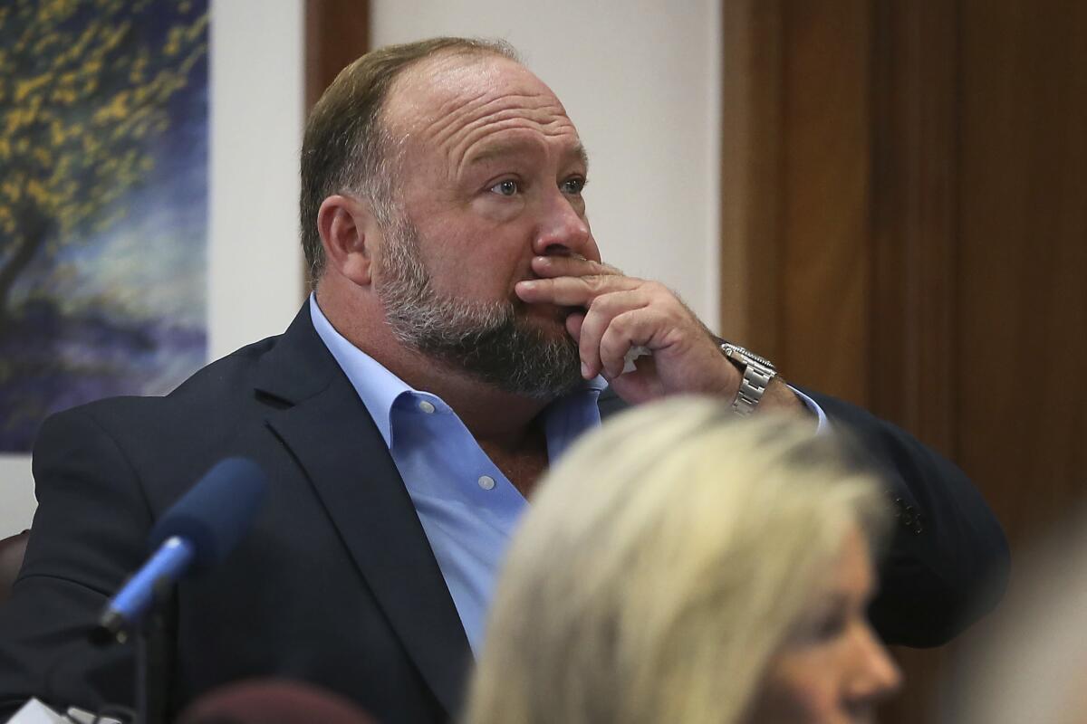 Alex Jones attempts to answer questions during his trial.