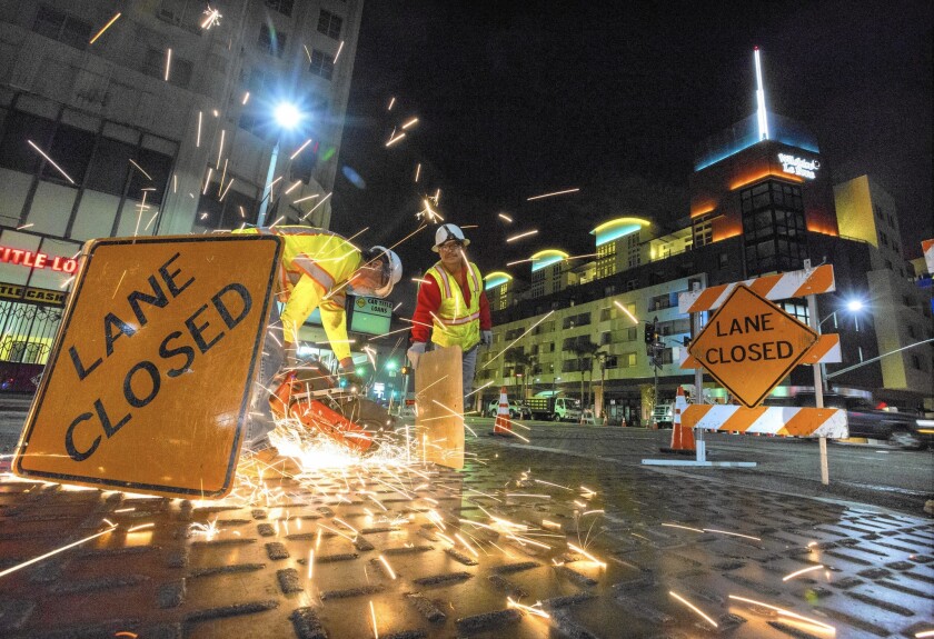 Workers cut loose metal plates in a project to relocate DWP lines for the Metro's expansion. Mayor Eric Garcetti said the Metro extension along Wilshire Boulevard is the nation’s largest public works program and his top priority.