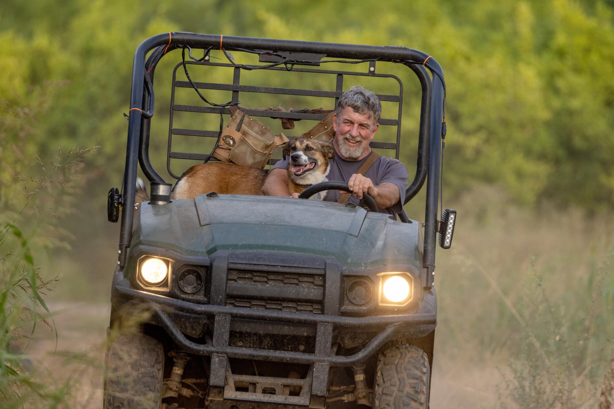 Greg Kirkpatrick, with his dog Ella, drives through Lindcove Ranch.