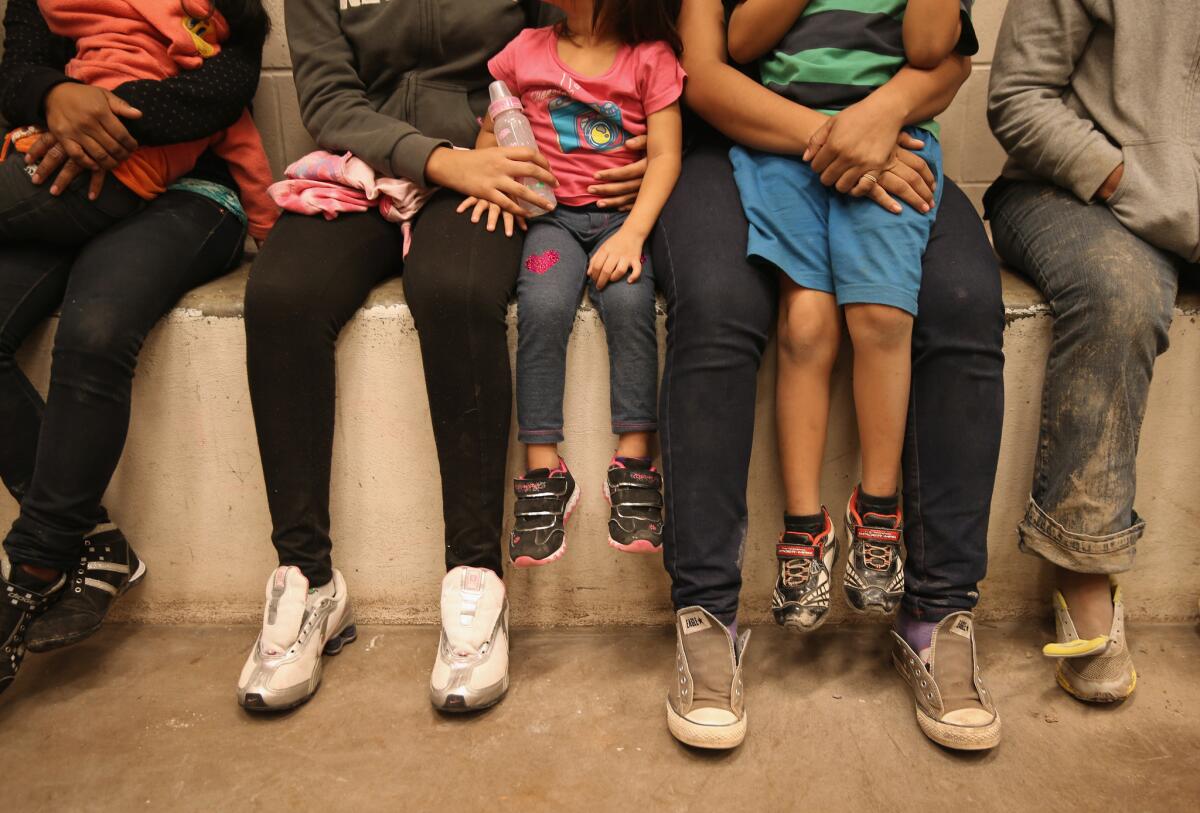 Women and children sit in a holding cell at a Border Patrol processing center.