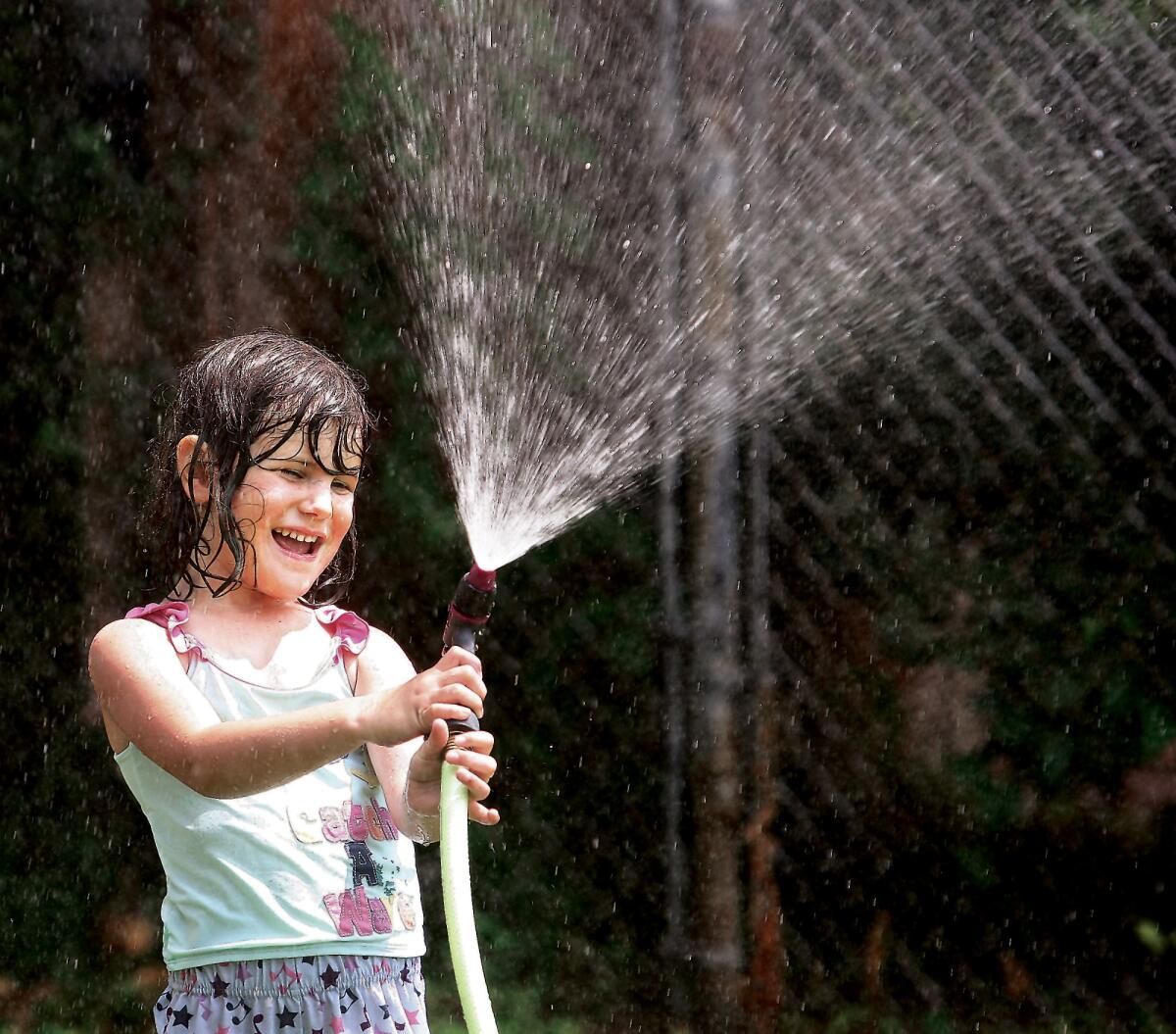 Five-year-old Claire Hayes knew how to beat the heat as she played with the garden hose in her front yard in Alton, Ill.