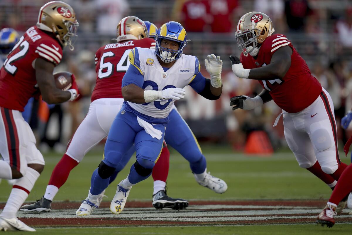 Rams defensive tackle Aaron Donald fights off a 49ers blocker while in pursuit of a running back.