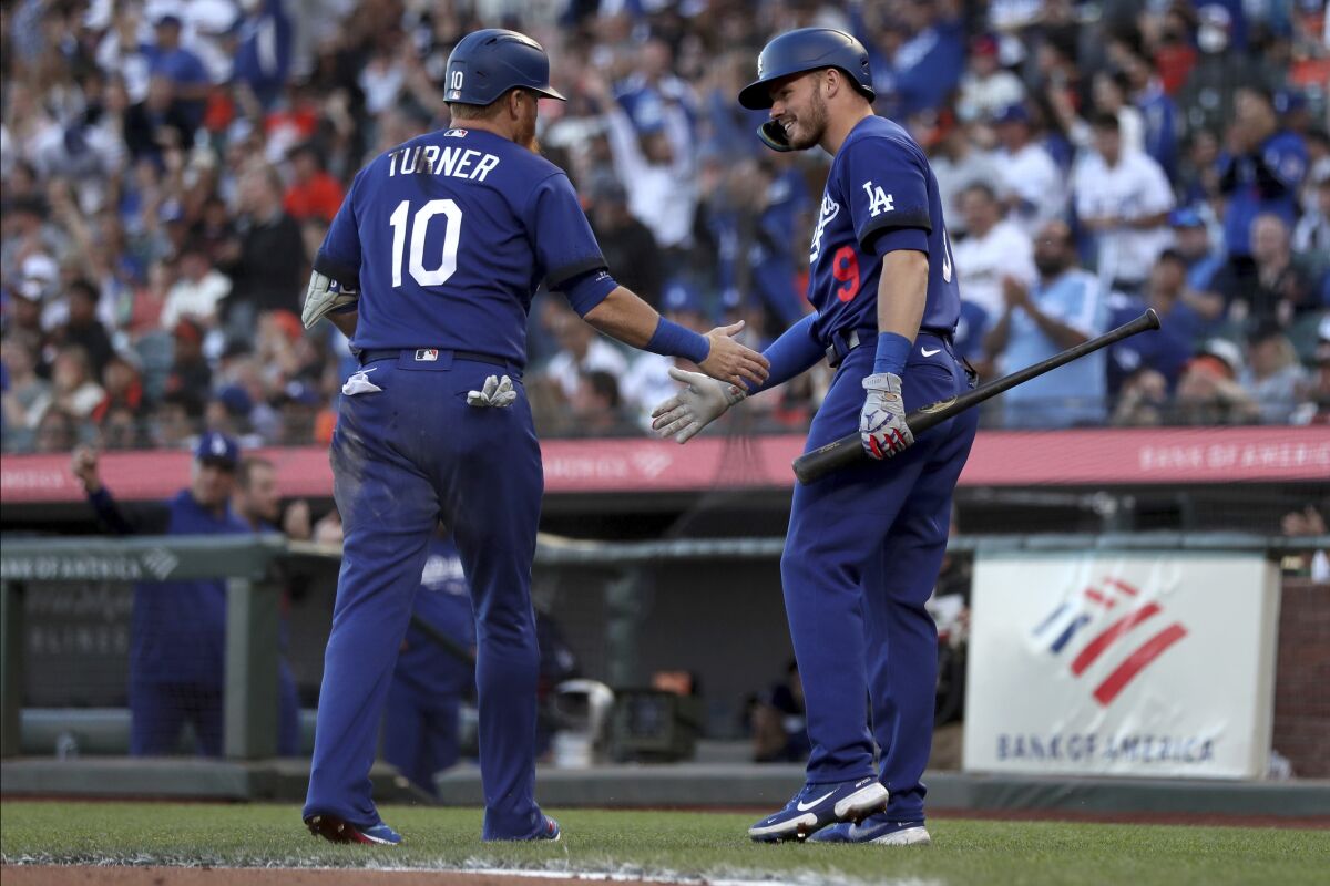 The Dodgers' Justin Turner, left, is congratulated by Gavin Lux after scoring on Chris Taylor's second-inning double June 10.