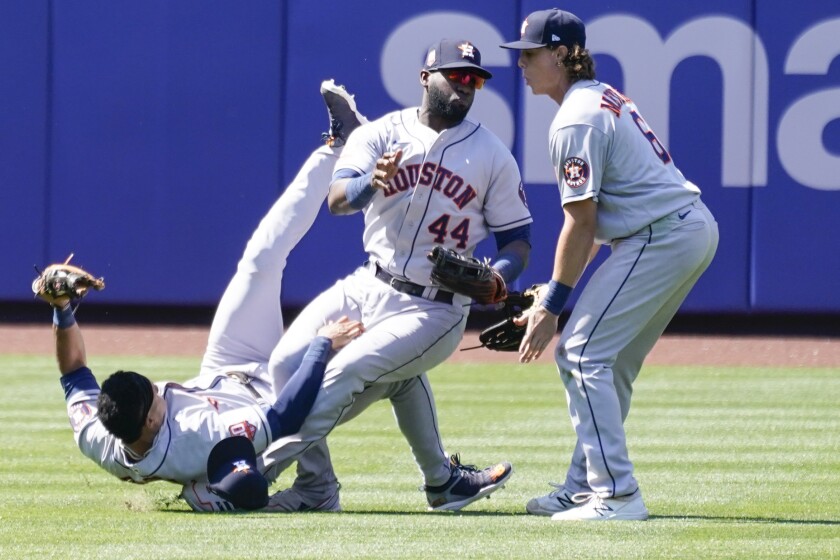 Houston Astros' Jake Meyers (6) watches as Jeremy Pena, left, and Yordan Alvarez (44) fall to the ground after colliding catching a fly ball by New York Mets' Dominic Smith during the eighth inning of a baseball game, Wednesday, June 29, 2022, in New York. (AP Photo/Mary Altaffer)