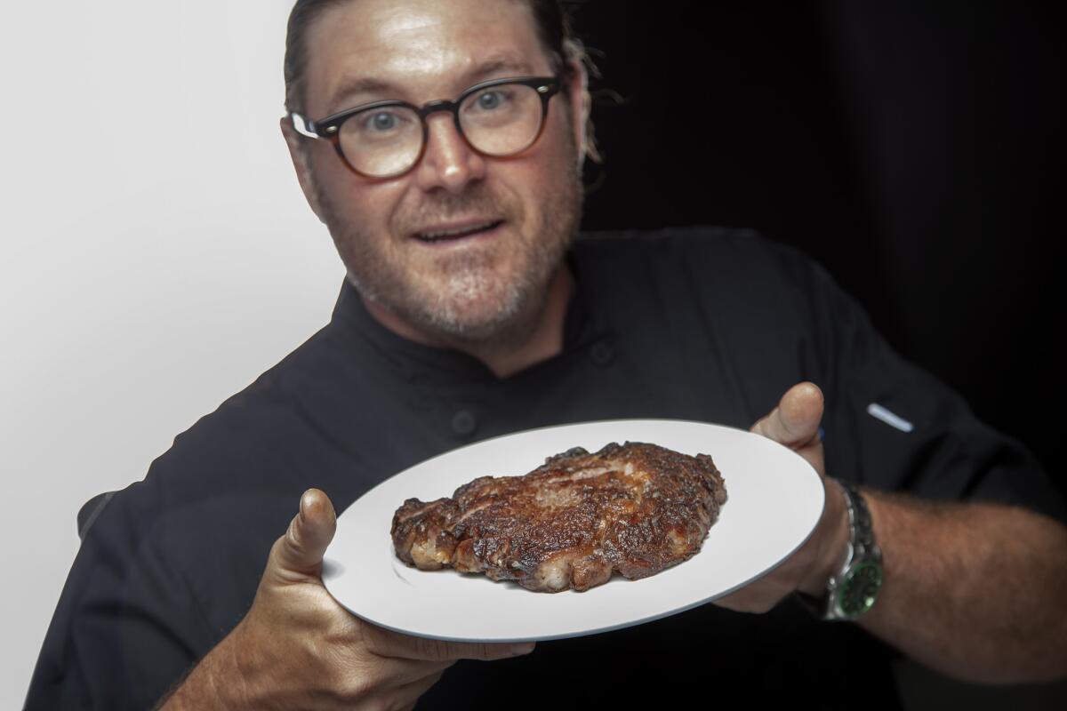 Chef David Lefevre with his rib-eye steak at the Times' Test Kitchen on July 28.