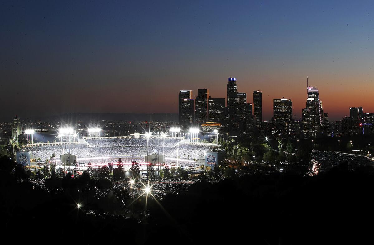Dodger Stadium in prepandemic times, with downtown L.A. lighted in the distance.