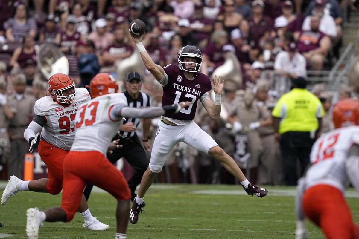 Texas A&M quarterback Haynes King (13) throws a pass as Sam Houston State defensive lineman Chris Scott (97) pressures him during the first half of an NCAA college football game Saturday, Sept. 3, 2022, in College Station, Texas. (AP Photo/David J. Phillip)
