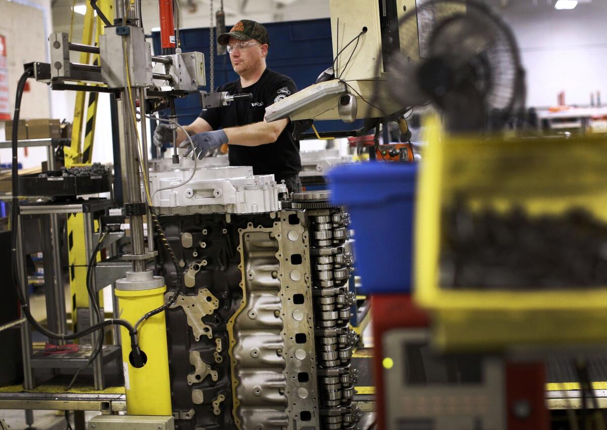 Jerry Drury installs parts on a truck engine assembly line at Volvo Trucks' powertrain manufacturing facility in Hagerstown, Md.