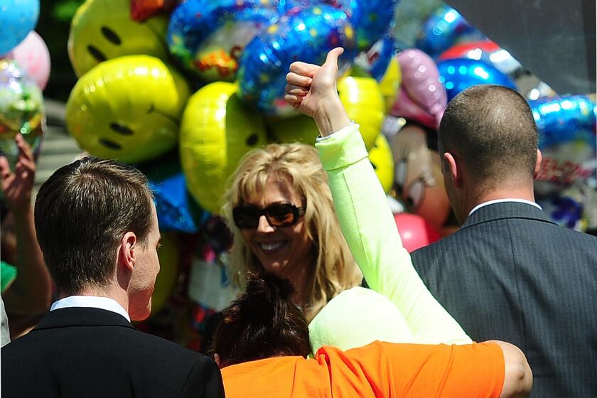 Gina DeJesus raises her thumb as she arrives at her family house in Cleveland.