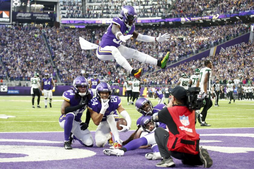 Minnesota Vikings safety Camryn Bynum (24) celebrates with teammates after intercepting a pass during the second half of an NFL football game against the New York Jets, Sunday, Dec. 4, 2022, in Minneapolis. The Vikings won 27-22. (AP Photo/Bruce Kluckhohn)