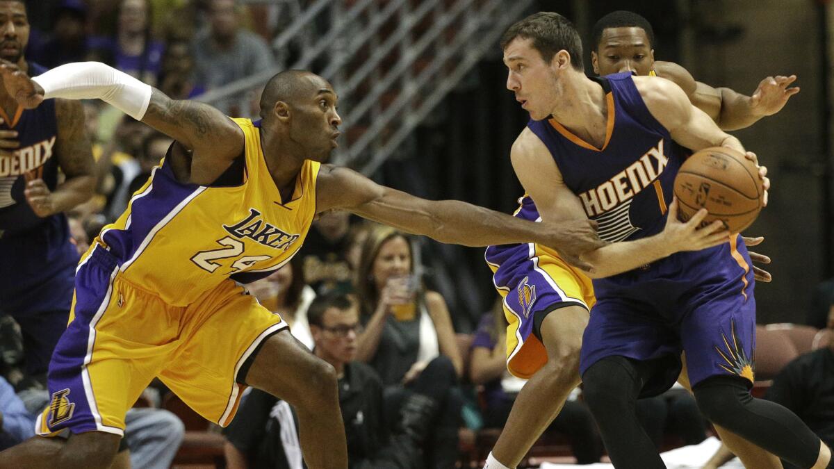 Lakers star Kobe Bryant, left, tries to steal the ball away from Phoenix Suns guard Goran Dragic during the first half of a Lakers' 114-108 preseason loss.