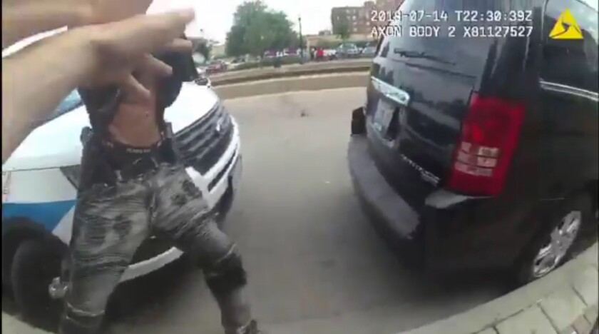 A body camera video released by the Chicago Police Department shows Harith Augustus with what appears to be a handgun in a holster on his right hip as he is confronted by Chicago police officers shortly before they fatally shot him on Saturday.
