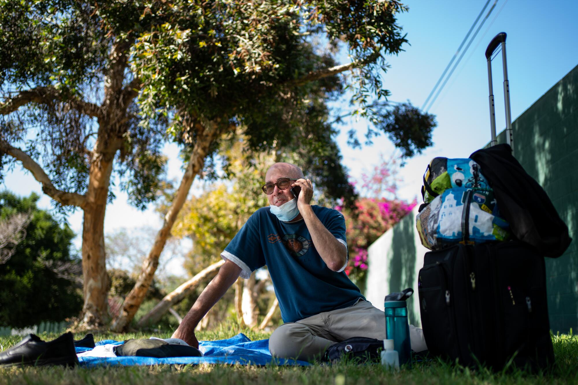 Terrance Whitten takes a phone call while he rests in the shade  at Pan Pacific Park