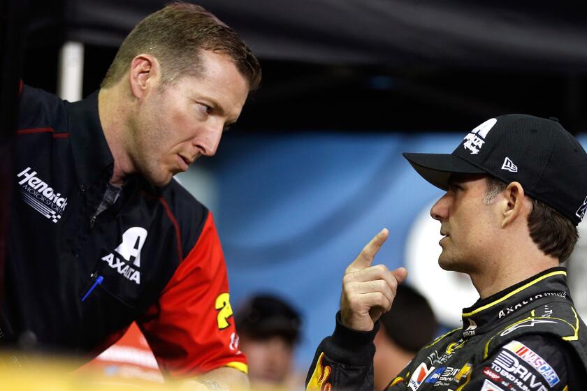 NASCAR driver Jeff Gordon, right, talks to crew chief Alan Gustafson on Friday during qualifying for the NASCAR Sprint Cup Series Ford EcoBoost 400 at Homestead-Miami Speedway.
