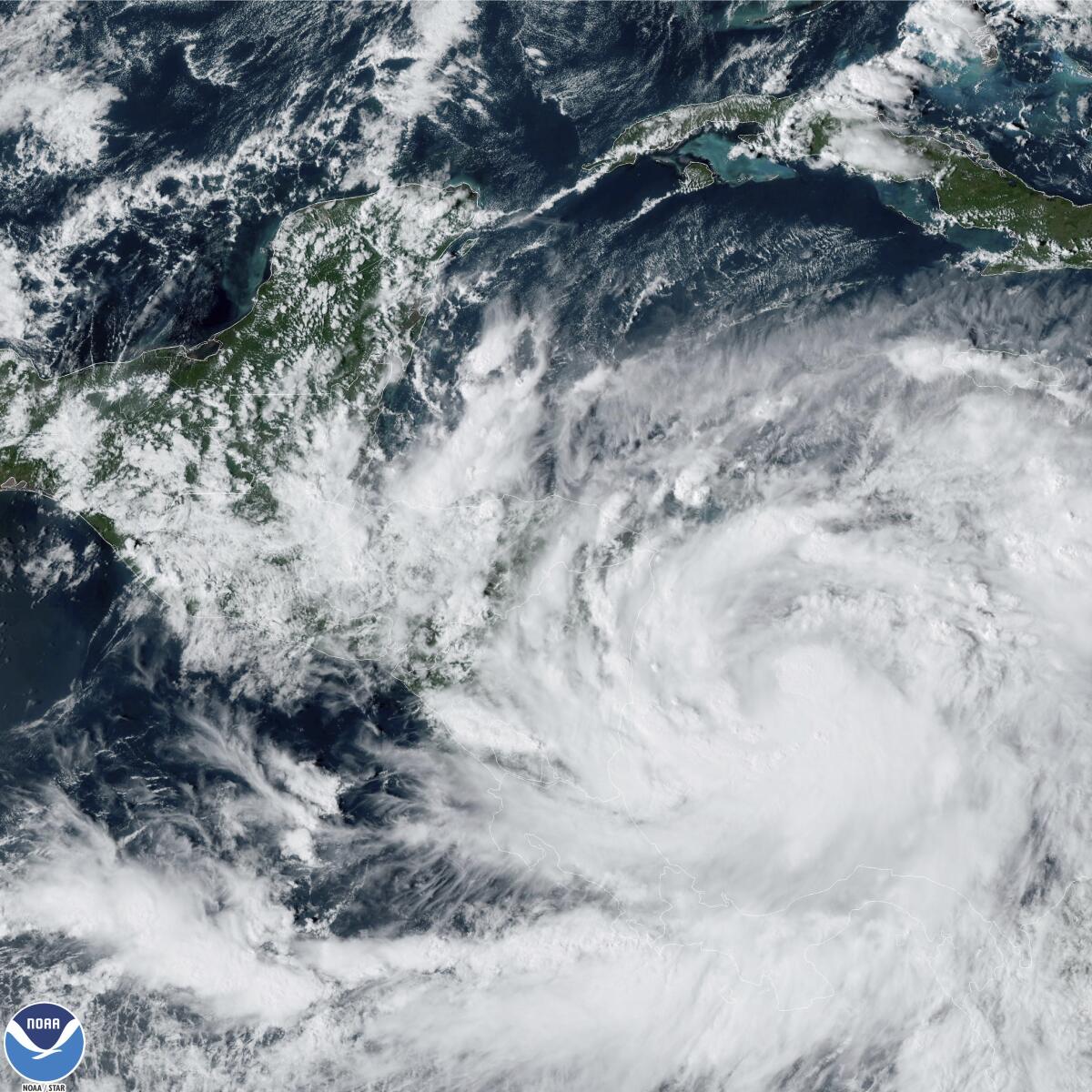 This Saturday, Oct. 8, 2022 satellite image made available by the U.S. National Oceanic and Atmospheric Administration shows Tropical Storm Julia, bottom right, at 4 p.m. EDT. Julia is gaining strength heading westward in the southern Caribbean, and authorities are preparing for a possible hurricane on Colombian islands and in Nicaragua. (NOAA via AP)
