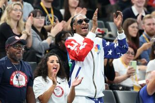 Rapper Snoop Dogg cheers for the U.S. during gymnastics team qualifying at the Olympics in Paris.