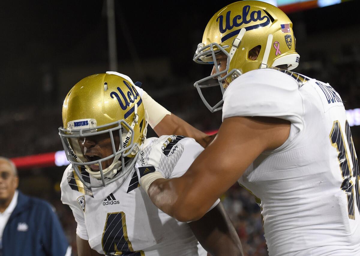 UCLA's Darren Andrews (4) and Thomas Duarte (18) celebrate after Andrews scored a touchdown in the first quarter on Oct. 15.