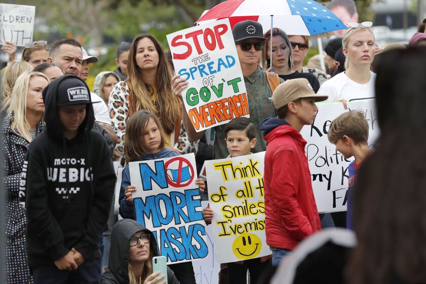 Kids and parents listen to guest speakers as they participate in the "Let the Kids Breathe" rally in front of Orange County Department of Education building in Costa Mesa on Monday. The effort is to call on Orange County educators to remove mask mandates for public schools including Orange County.
