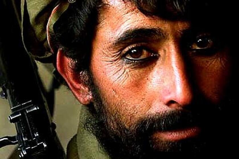 A defeated Taliban soldier waits for orders after being taken by Northern Alliance troops at Post Garari Merza Kabir six miles northwest of the Salang Pass tunnel. He wears customary eyeliner, a tradition in Afghanistan.