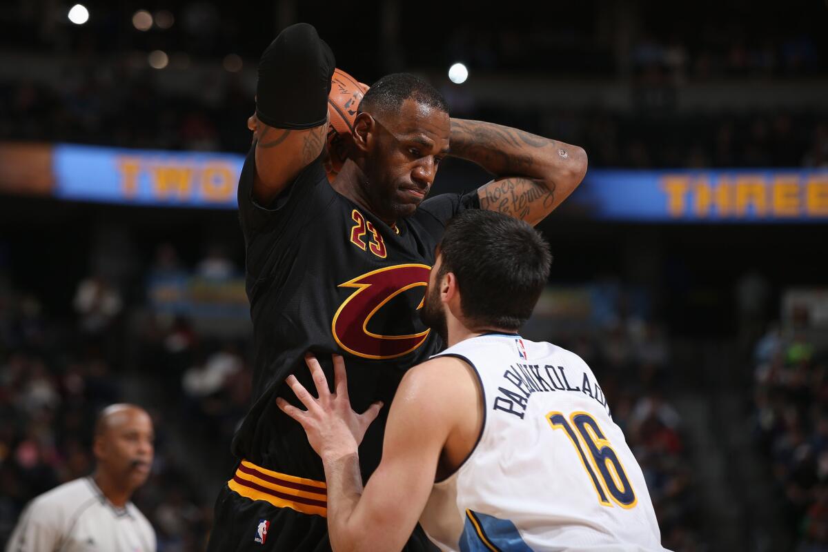 Cavaliers forward LeBron James controls the ball against Nuggets forward Kostas Papanikolaou.