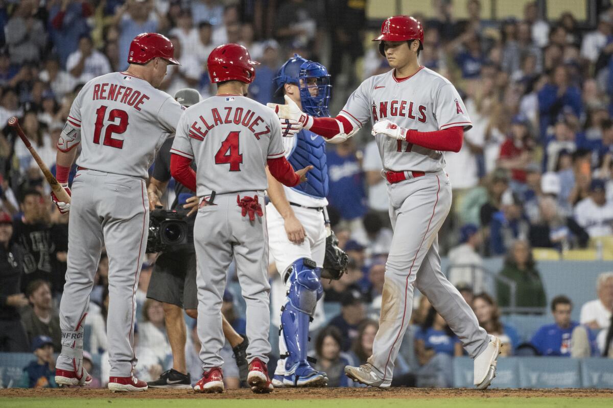 The Angels' Shohei Ohtani celebrates with Hunter Renfroe and Andrew Velazquez after hitting a homer.