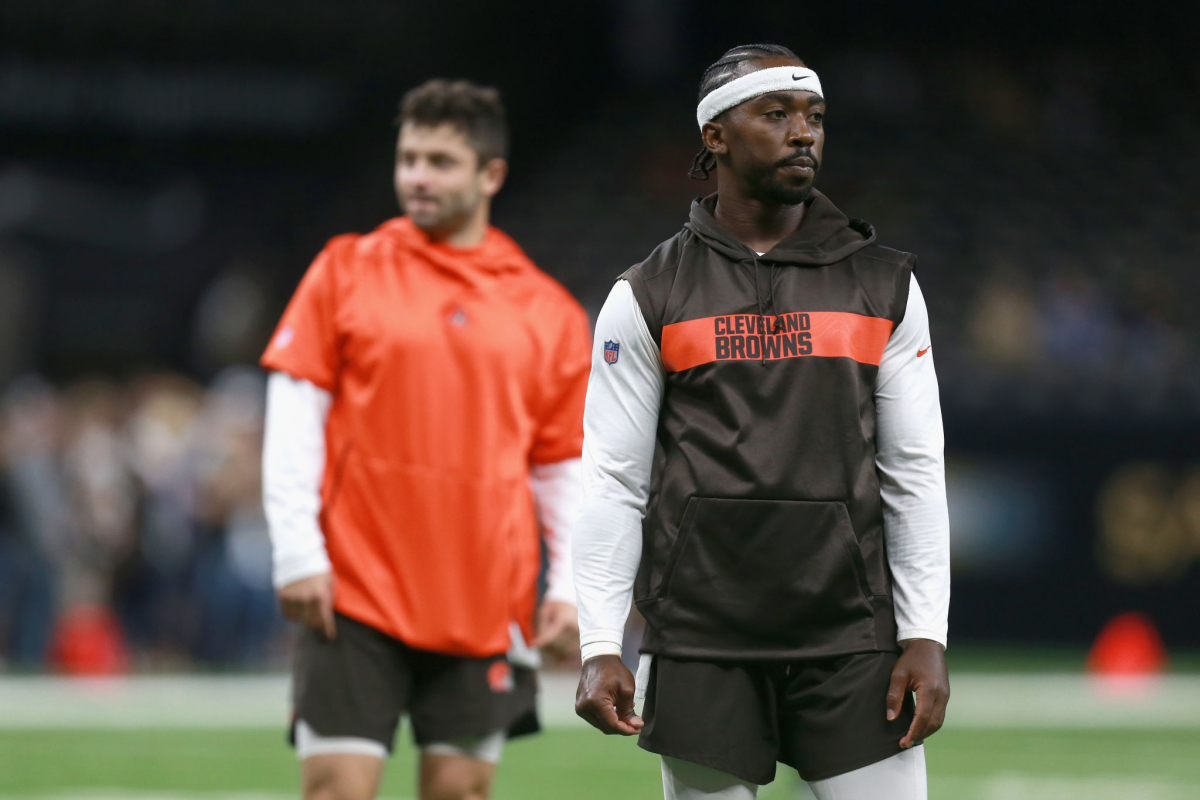 Cleveland Browns quarterbacks Tyrod Taylor, right, and Baker Mayfield stand on the field.