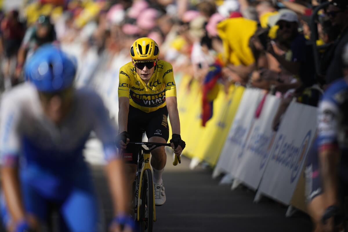Denmark's Jonas Vingegaard, wearing the overall leader's yellow jersey, crosses the finish line of the eighteenth stage.