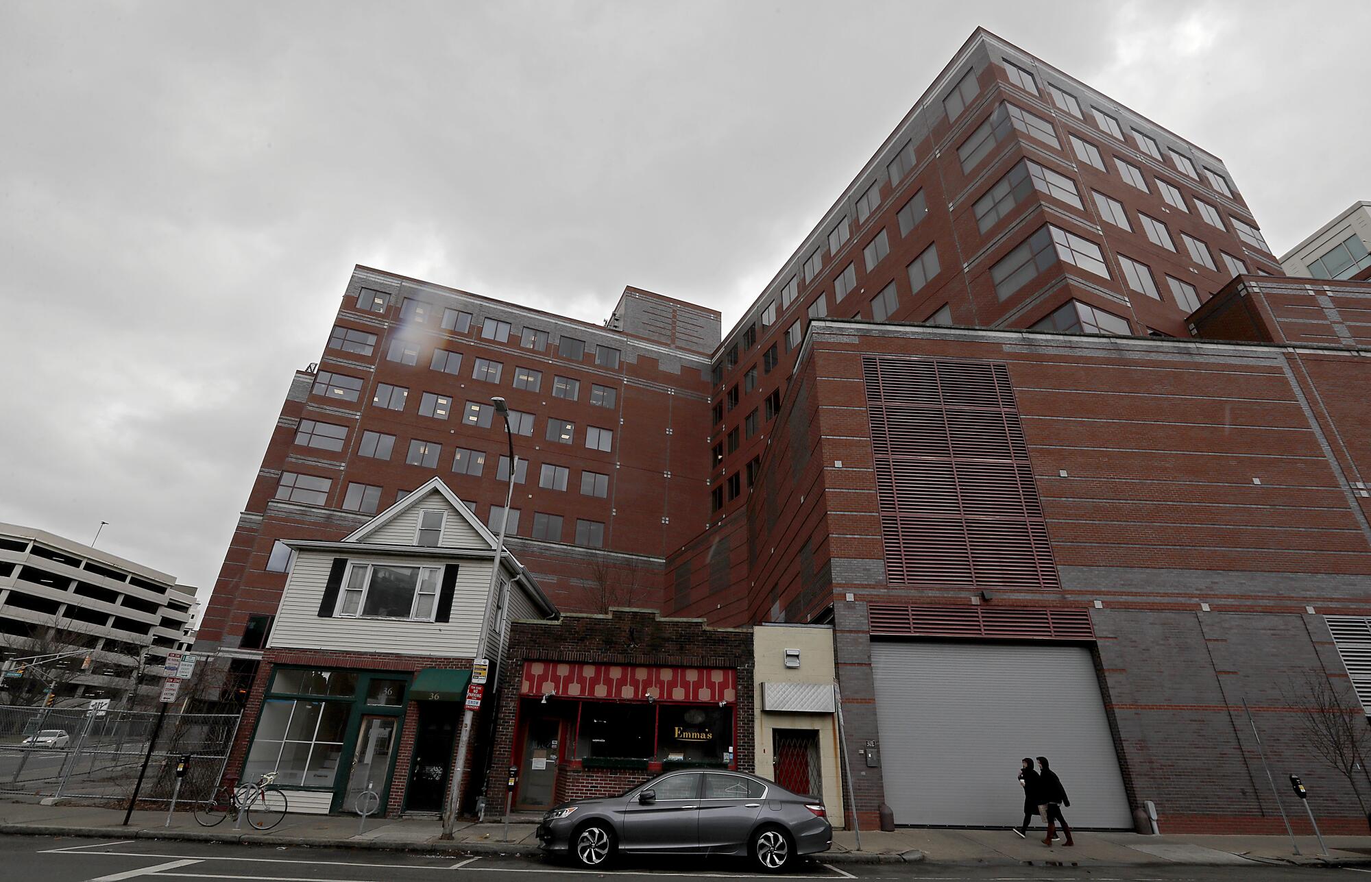 A pair of old structures stand in the shadow of new development around Kendall Square in Cambridge.