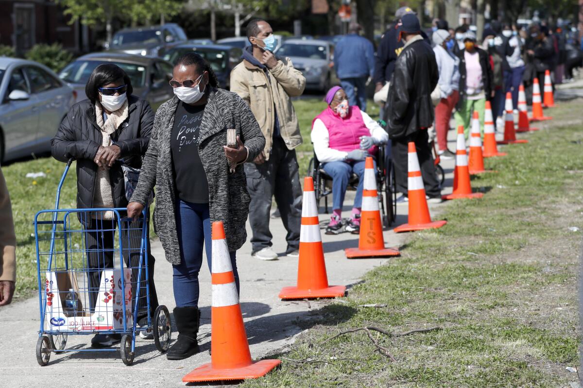 Backers of direct-cash payment programs such as universal basic income say such efforts could help people struggling with basic needs, such as these Chicago residents lined up for a food giveaway sponsored by the Greater Chicago Food Depository during the pandemic.