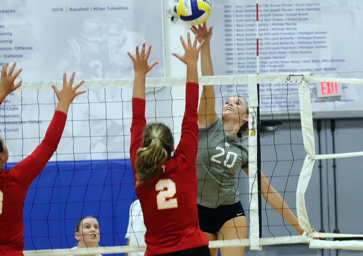 Newport Harbor's Laine Briggs (20) taps the ball over Orange Lutheran's Kristin Russell (2).