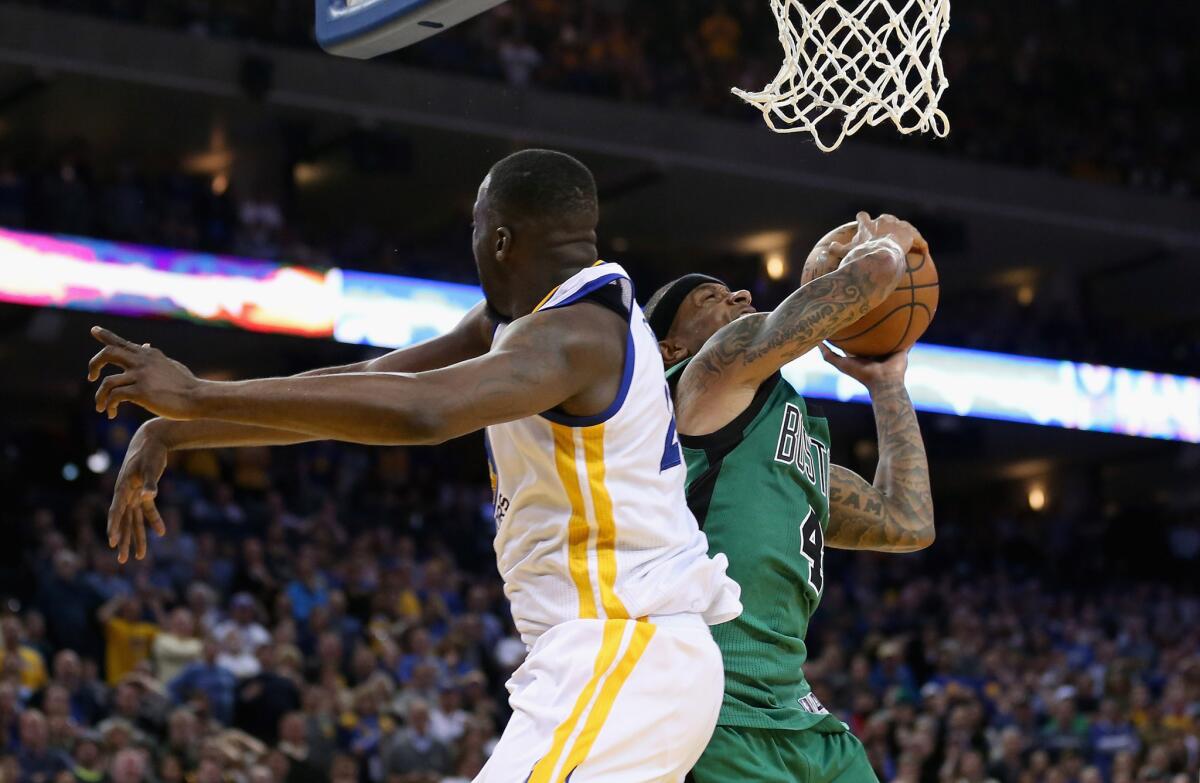Celtics guard Isaiah Thomas avoids a block from Warriors forward Draymond Green and gets a basket late in the fourth quarter of Boston's 109-106 victory over Golden State on April 1.