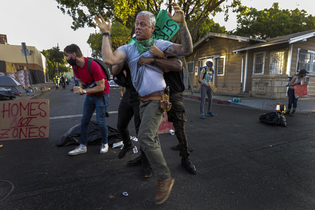 Protesters restrain a man who had gotten into a scuffle with another protester at an intersection in Hollywood