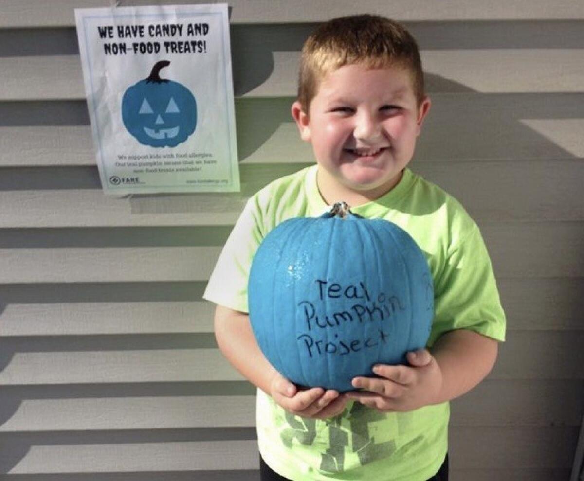 Erik Geier, 5, poses with a teal pumpkin that will be displayed outside his family's Elkhart, Ind., home for Halloween. The Teal Pumpkin Project is a campaign meant to encourage non-food treats for children with allergies.